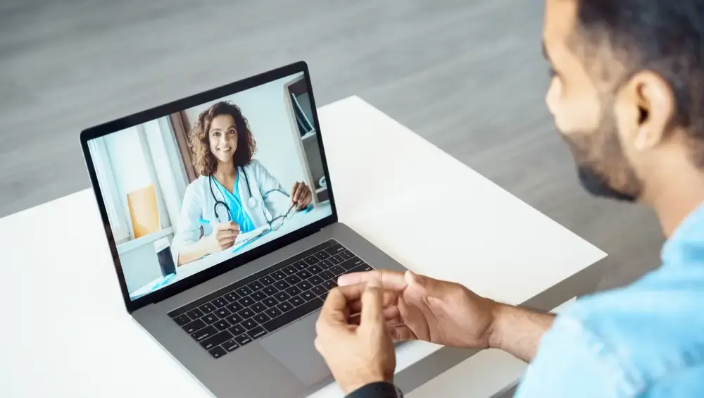 a doctor gives a digital consult on a laptop