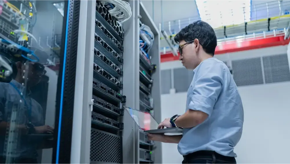 man with a laptop programming networking hardware