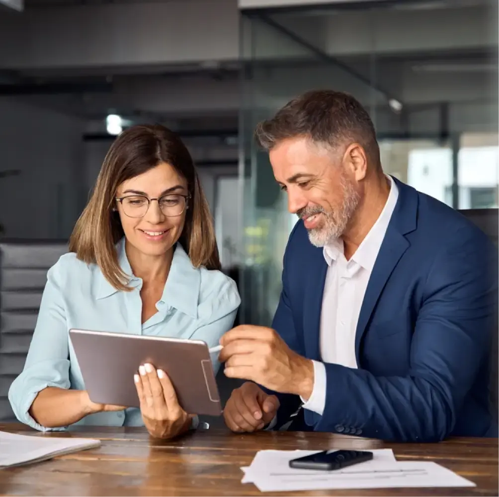 two people consult at a table with a tablet
